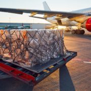 A large piece of cargo getting ready to get put on plane