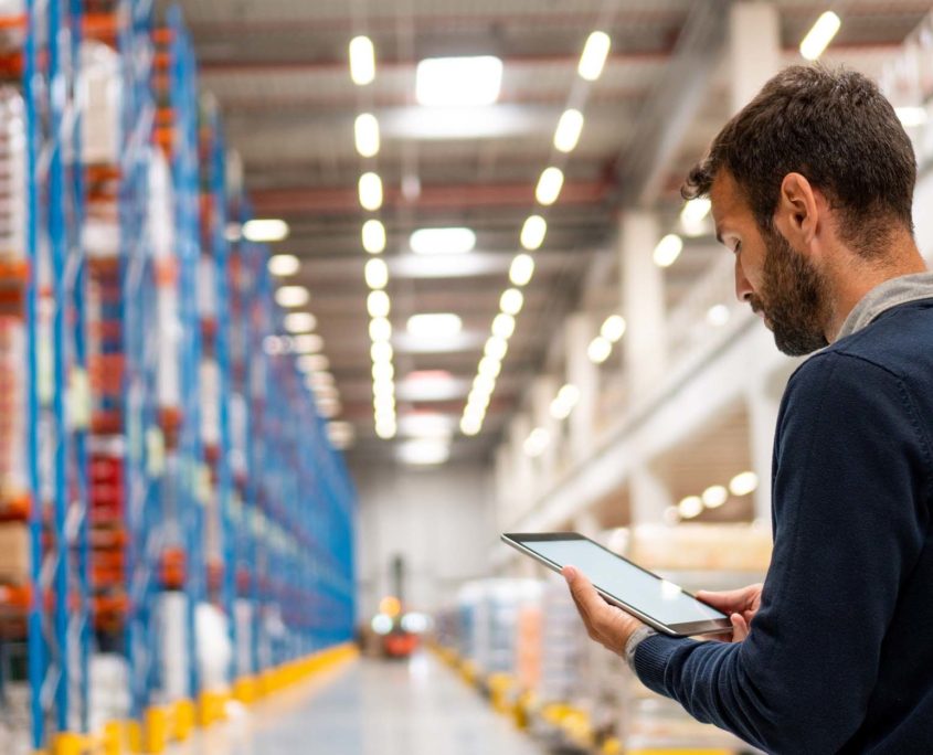 Warehouse manager looking at logistics over tablet