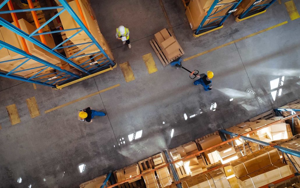 Overhead view of warehouse workers partaking in successful logistics optimization