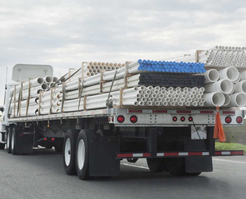 View of a flatbed freight brokers service truck with piping