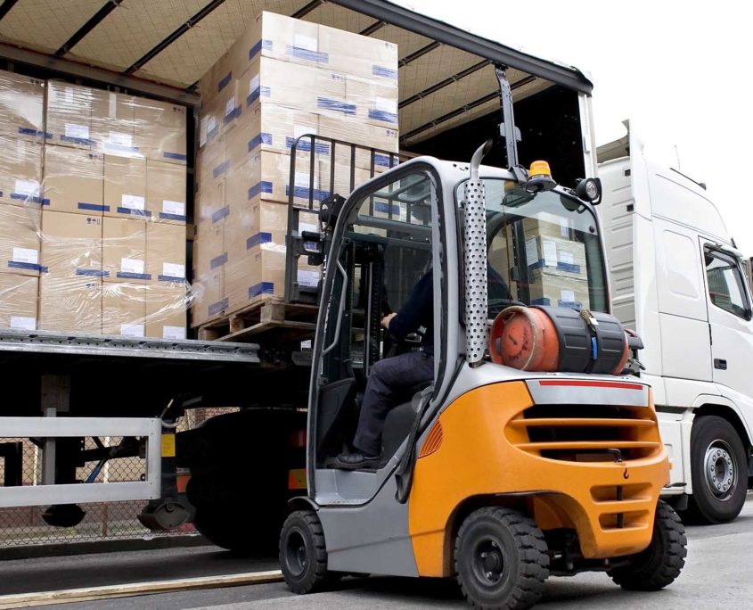 View of a LTL freight broker forklift driver loading freight into truck