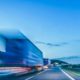 Background photograph of a highway. Truck on a motorway, motion blur, light trails. Evening or night shot of trucks doing logistics and transportation-1